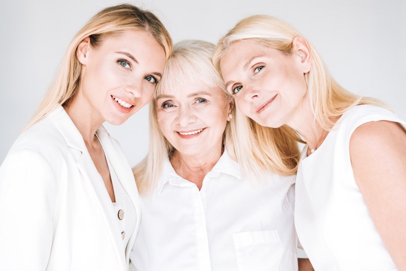 Trzy uśmiechnięte kobiety w różnym wieku