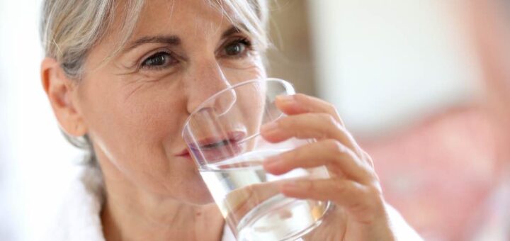 Dojrzała kobieta pije wodę ze szklanki