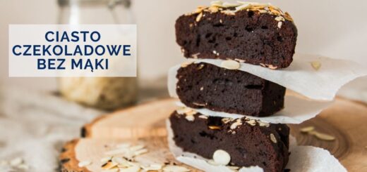 Ciasto czekoladowe. 3 kawałki ciasta czekoladowego postawione na drewnianej desce jedno na drugim i przełożone papierem do pieczenia.