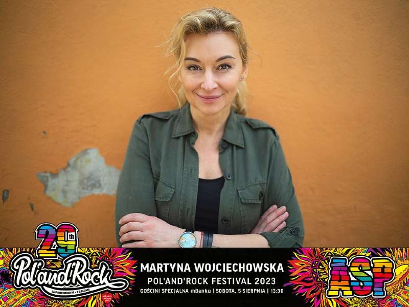 Martyna Wojciechowska na tle ściany. Pod zdjęciem napis: “Pol’and’Rock Festiwal”