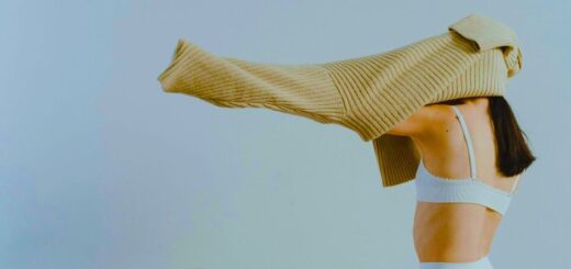 Kobieta w biustonoszu zakłada sweter